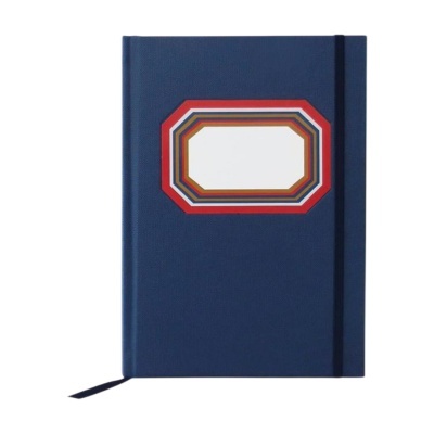 Caderno azul escuro com etiqueta colorida e elástico preto.