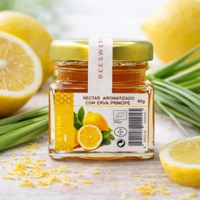 Frasco de néctar aromatizado com erva príncipe e limões ao fundo