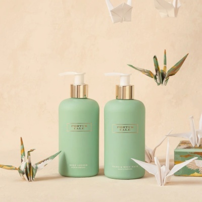 Frascos verdes de body lotion e hand & body wash com figuras de origami
