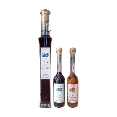 Três garrafas de licor artesanal com etiquetas de mirtilo e tamarilho