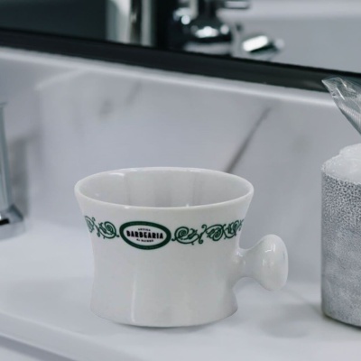 Taça branca de cerâmica com decoração verde e texto Antiga Barbearia de Bairro