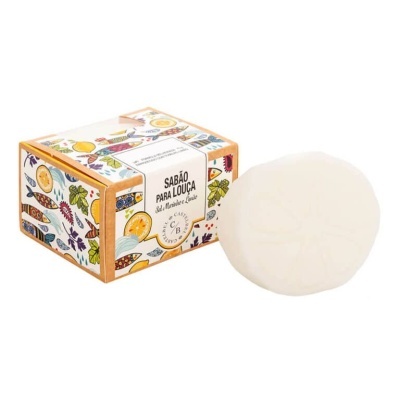 Sabão para louça branco ao lado de caixa colorida com ilustrações de frutas e texto