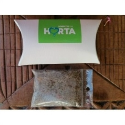 Caixa branca com logotipo verde e saco transparente com terra sobre rattan