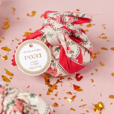 Sabonete aromático rosa embalado em tecido floral com etiqueta e confetis dourados