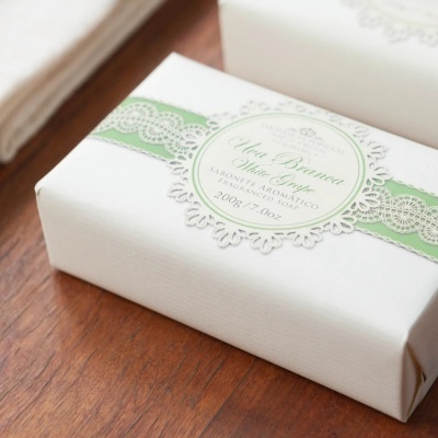 Sabonete aromático embalado em papel branco com etiqueta circular verde e branca