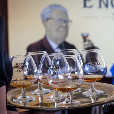 Copos de licor com a inscrição BEIRÃO DHONRA 100 numa bandeja metálica