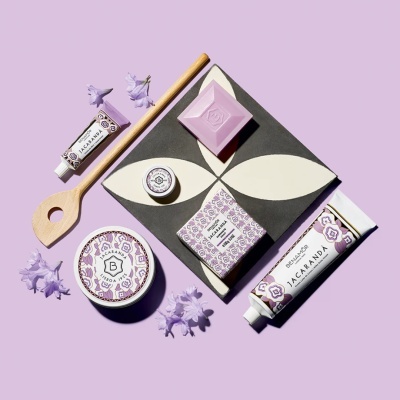 Produtos de beleza Benamôr Jacarandá com embalagens lilás e brancas e flores lilás