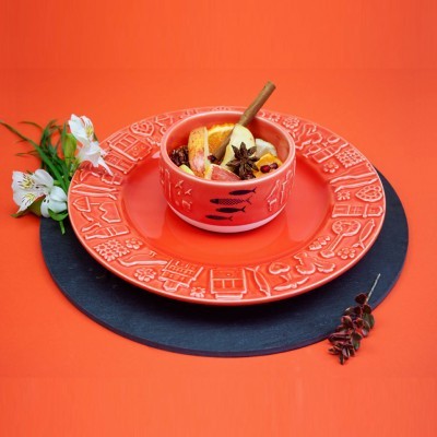 Conjunto de serviço de mesa coral com tigela e prato decorados, bebida com especiarias e frutas, fundo laranja