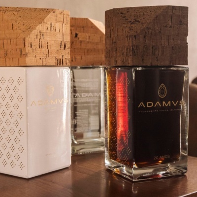 Garrafas Adamvs com tampas de cortiça e caixa branca com padrão perfurado
