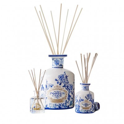 Três difusores de ambiente com frascos de vidro decorados em azul e branco e varas de varetas.