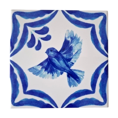 Azulejo branco com pintura de pássaro e ornamentos azuis