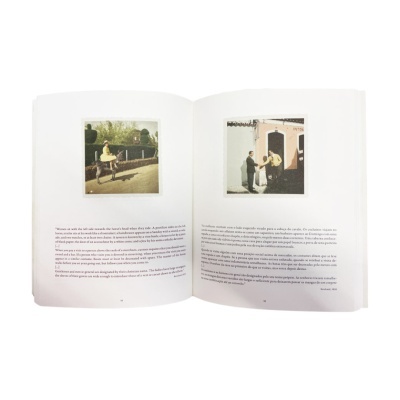 Livro aberto com texto em português e duas fotografias coloridas numa superfície branca