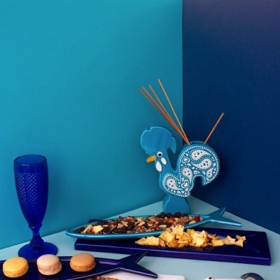 Galo azul decorativo com pratos de peixe e petiscos em ambiente azul