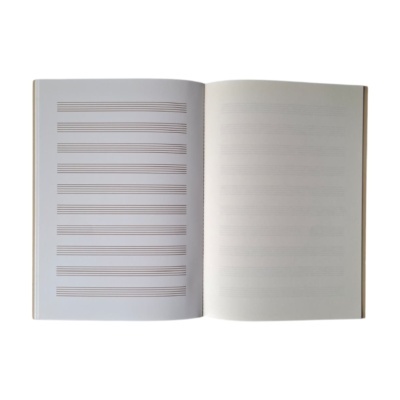 Caderno de pautas musicais aberto mostrando folhas com linhas para partituras