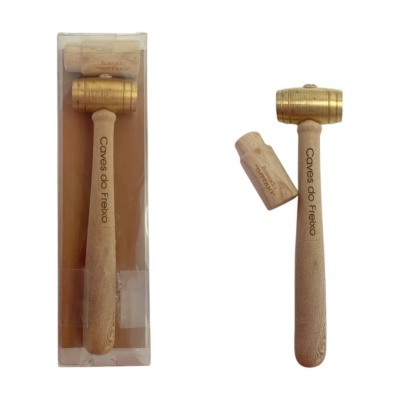 Martelo de madeira e metal dourado com texto Caves do Freixo e embalagem transparente