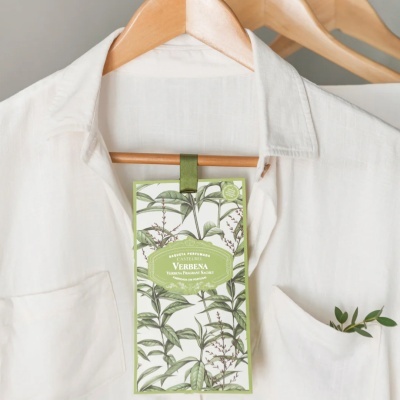 Saco perfumado de verbena pendurado em camisa branca num cabide de madeira