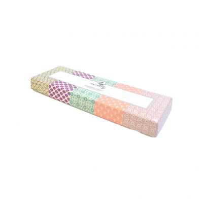 Embalagem retangular com padrões geométricos coloridos e etiqueta branca central