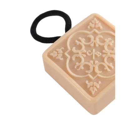 Elástico de cabelo com pendente quadrado bege com padrão ornamental em relevo e elástico preto