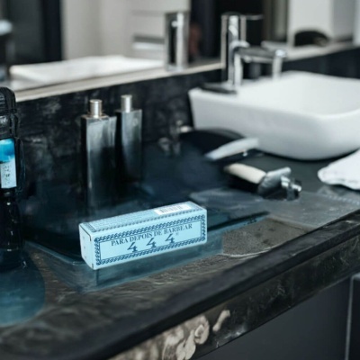 Caixa azul clara para pós-barba na bancada de casa de banho