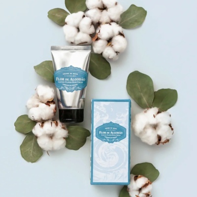 Creme de mãos Flor de Algodão da Castelbel com embalagem prateada e caixa azul claro com flores de algodão