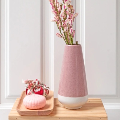Vaso cerâmico rosa com flores, bandeja de madeira com saboneteira e saco decorativo.