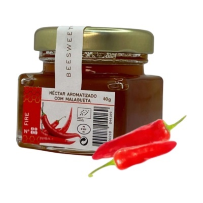Frasco de néctar aromatizado com malagueta e duas malaguetas vermelhas frescas ao lado