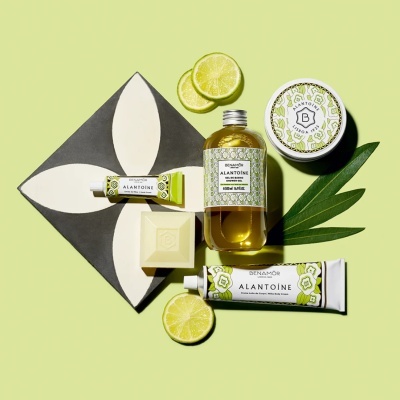 Produtos de cuidados pessoais Benamôr Alantoíne com embalagens verdes e brancas, rodela de limão e folha verde sobre fundo verde claro.