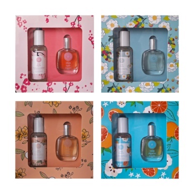 Quatro conjuntos de perfume em embalagens decoradas com flores e frutas, cada set com frasco de spray e eau de toilette