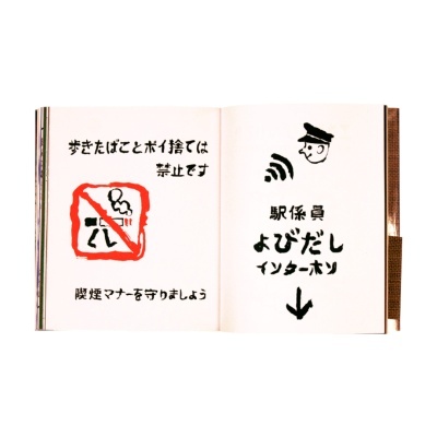 Livro aberto com texto e ilustrações em japonês sobre proibição de fumar e serviço de interfone com funcionário