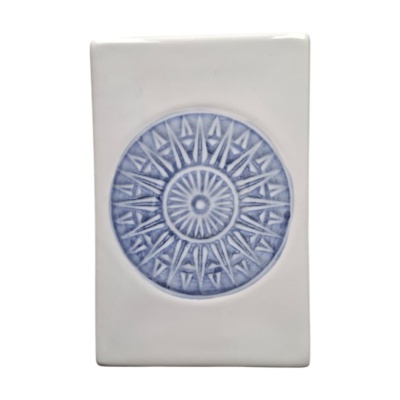 Azulejo branco com relevo circular azul ao centro