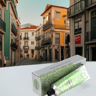 Tubo e caixa do produto Barbearia com design verde e branco sobre superfície branca e fundo urbano