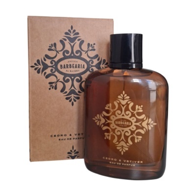 Frasco de perfume castanho com tampa preta e caixa castanha com design decorativo em preto