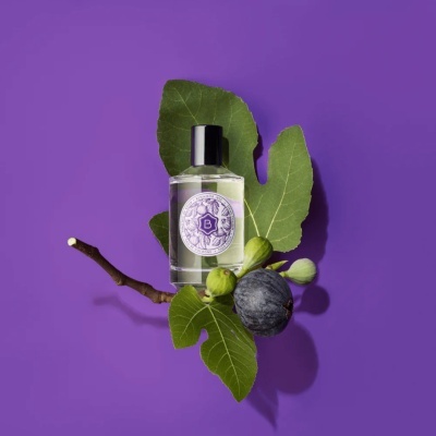 Frasco de Eau de Cologne Benamôr com folhas e figos em fundo roxo
