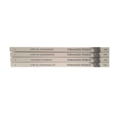 Conjunto de quatro livros brancos com títulos em várias línguas e autor Fernando Pessoa.