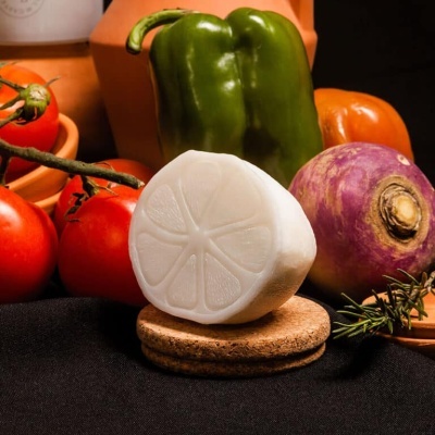 Legumes frescos e queijo branco em base de cortiça sobre tecido preto