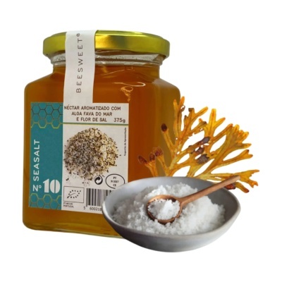 Frasco de néctar aromatizado com alga e flor de sal com tigela de flor de sal e colher.