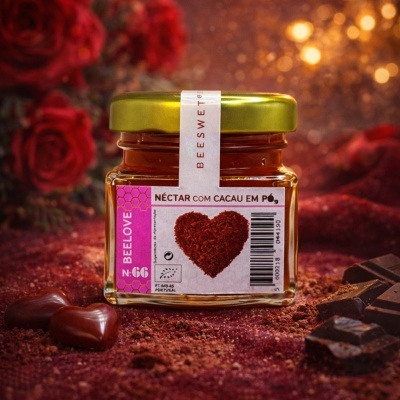 Frasco de néctar com cacau em pó com rótulo cor de rosa e tampa dourada rodeado por rosas e chocolates