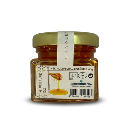 Frasco pequeno de mel multifloral biológico com tampa dourada e rótulo branco com texto e imagem de mel