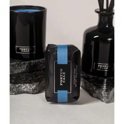 Conjunto de produtos de banho PORTUS CALE em embalagem preta com detalhes em azul e bases de pedra cinza.