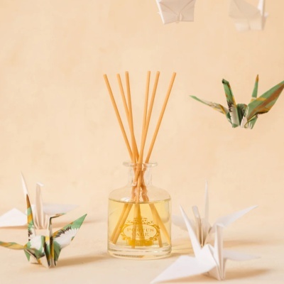 Frasco de vidro com varetas e figuras de origami envolta