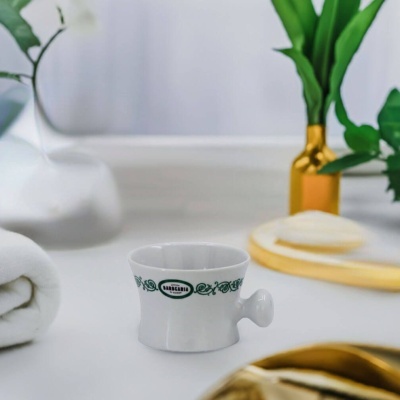 Taça branca de porcelana com punho pequeno e decoração verde em superfície branca