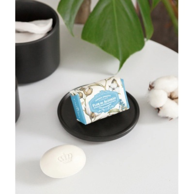 Sabonete branco com coroa e barra de sabonete Flor de Algodão num prato preto
