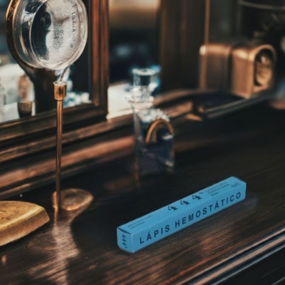 caixa azul de lápis hemostático num tampo de madeira com objetos ao fundo