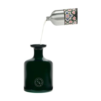 Garrafa de vidro verde escuro e frasco metálico prateado decorado