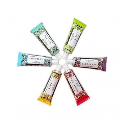 Seis tubos de creme coloridos dispostos em círculo sobre fundo branco