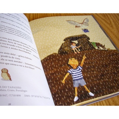 Livro infantil aberto com texto em português e ilustração colorida de crianças e animais na chuva