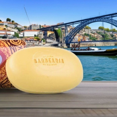 Sabonete oval amarelo com gravação em superfície de madeira com fundo urbano e ponte sobre rio
