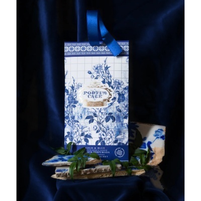 Saco perfumado azul e branco com padrão floral, azulejos e folhas verdes.