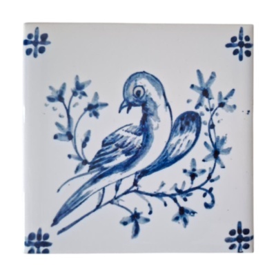 Azulejo cerâmico branco com pássaro e flores pintados em azul.