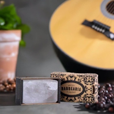 Sabonete artesanal em barra com embalagem decorativa e guitarra ao fundo